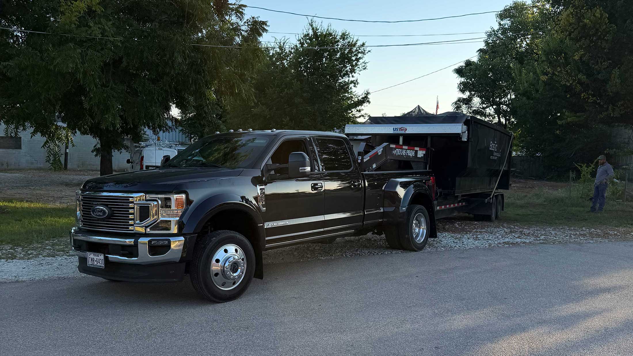 C3 Rentals delivery truck carrying a roll-off dumpster in East Texas